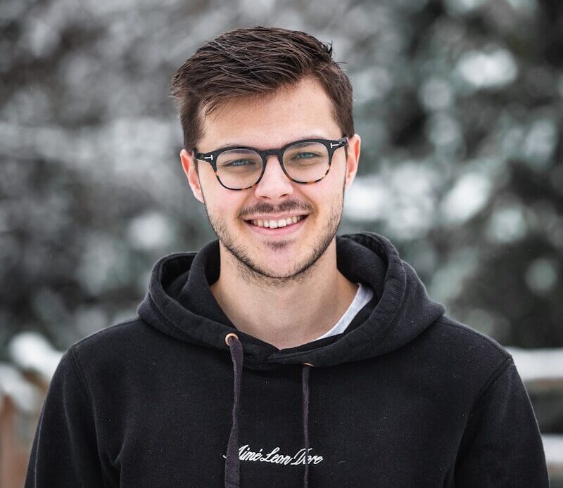 man in black hoodie wearing black framed eyeglasses
